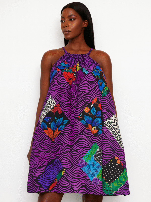 Purple halter-neck African print dress with multicolored patchwork patterns worn by a Black female model.